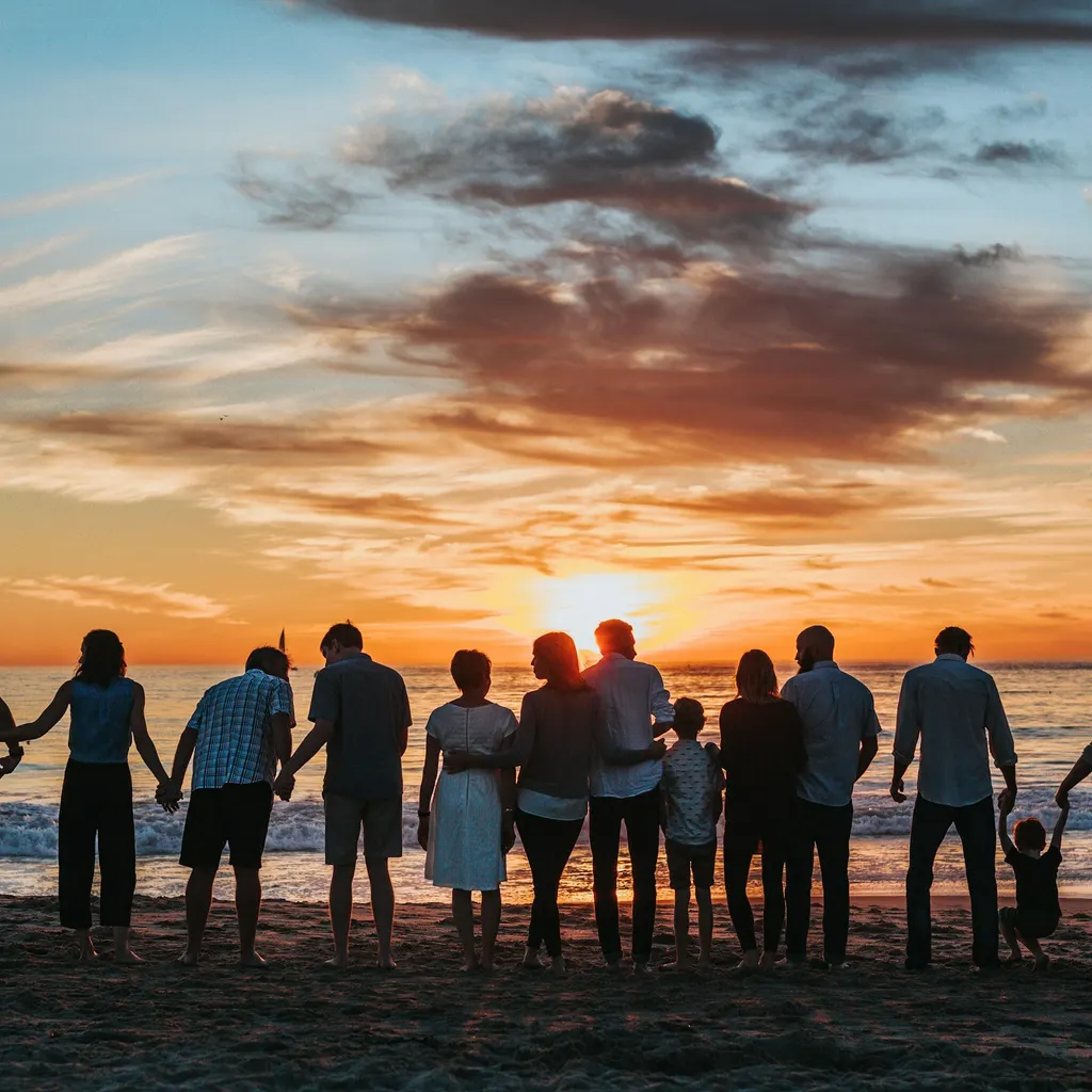 A family walks hand in hand along the beach at sunset.